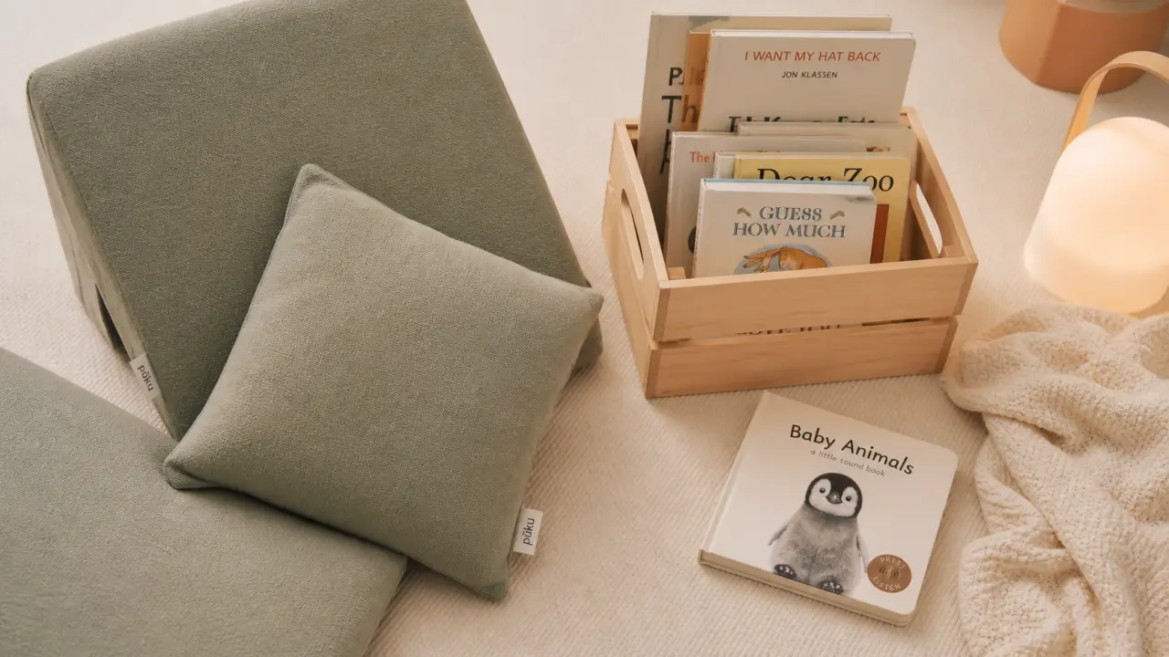 Coin lecture bebe cosy sur tapis crème, assise basse et livres